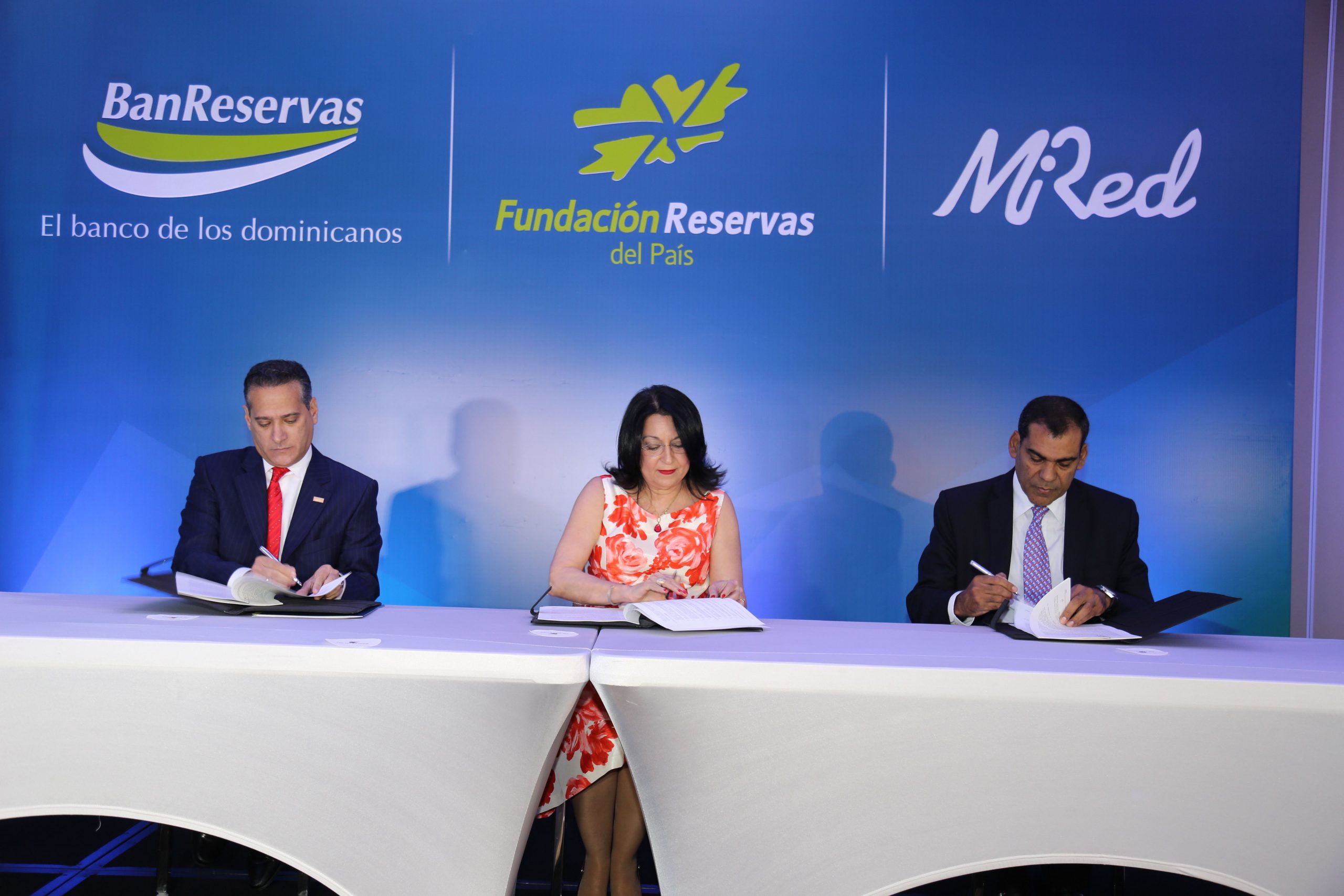 Rienzi Pared Pérez, de BanReservas; Rosa Rita Álvarez, de al Fundación Reservas del País, y Luis Bencosme, de Mi Red, firman el acuerdo.