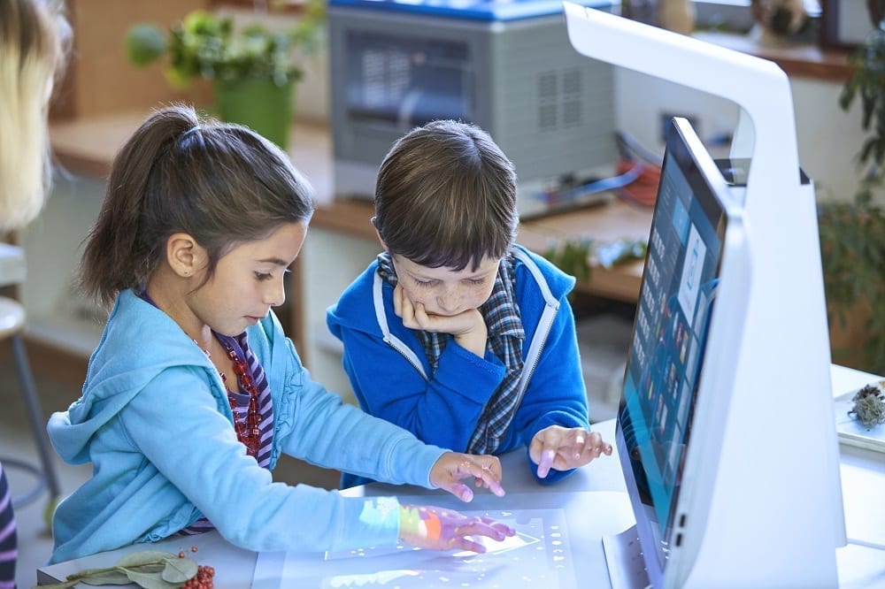 two students creating a project using a sprout pro by hp.