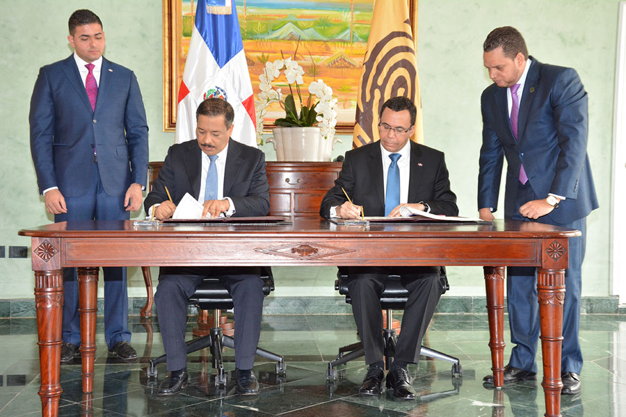 Roberto Rosario, presidente de la JCE, y el canciller Andrés Navarro, durante la firma del acuerdo de colaboración para documentar a dominicanos residentes en el exterior. /GABRIEL ALCÁNTARA.