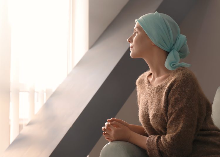Young woman with cancer in headscarf indoors
