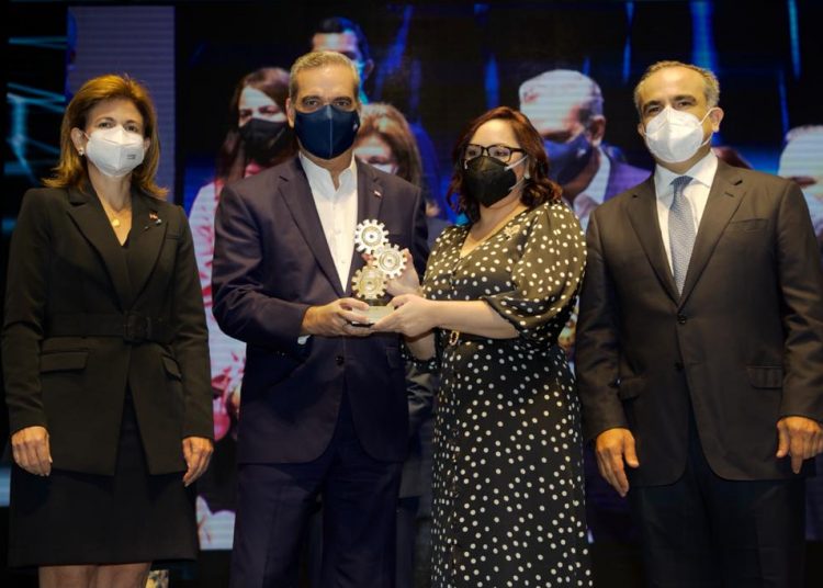 Elizabeth Mena recibe el galardón de Luis Abinader, Raquel Peña y Celso Marranzini.