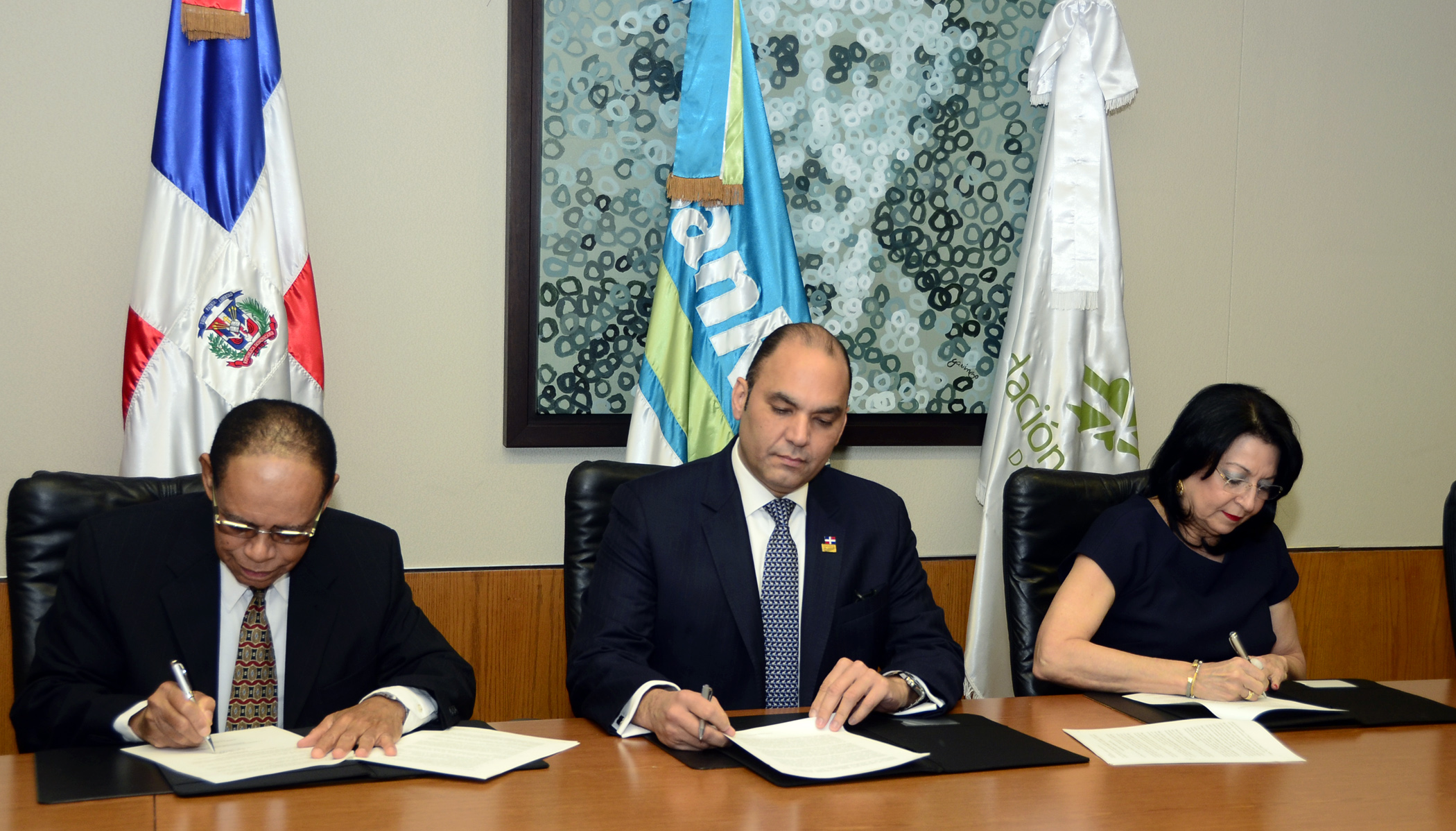 Lidio Cadet, Enrique Ramírez Paniagua y Rosa Rita Álvarez durante la firma del acuerdo en la Torre BanReservas.