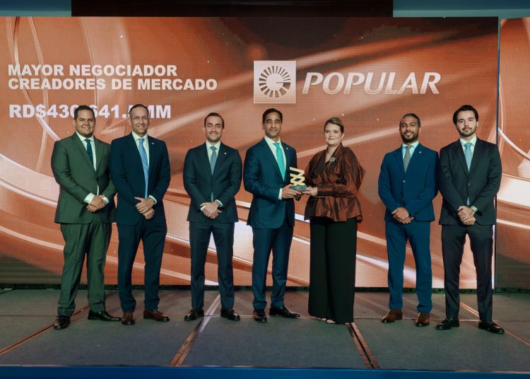 Edward Baldera, vicepresidente de Tesorería, Mercado de Capitales y Banca Institucional del Banco Popular, junto a su equipo, recibió el premio de manos de Elianne Vilchez, vicepresidenta ejecutiva de la Bolsa y Mercado de Valores de la República Dominicana.