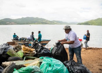 Trabajadores de la minera recogen desperdicios en las riberas de la presa de Hatillo.