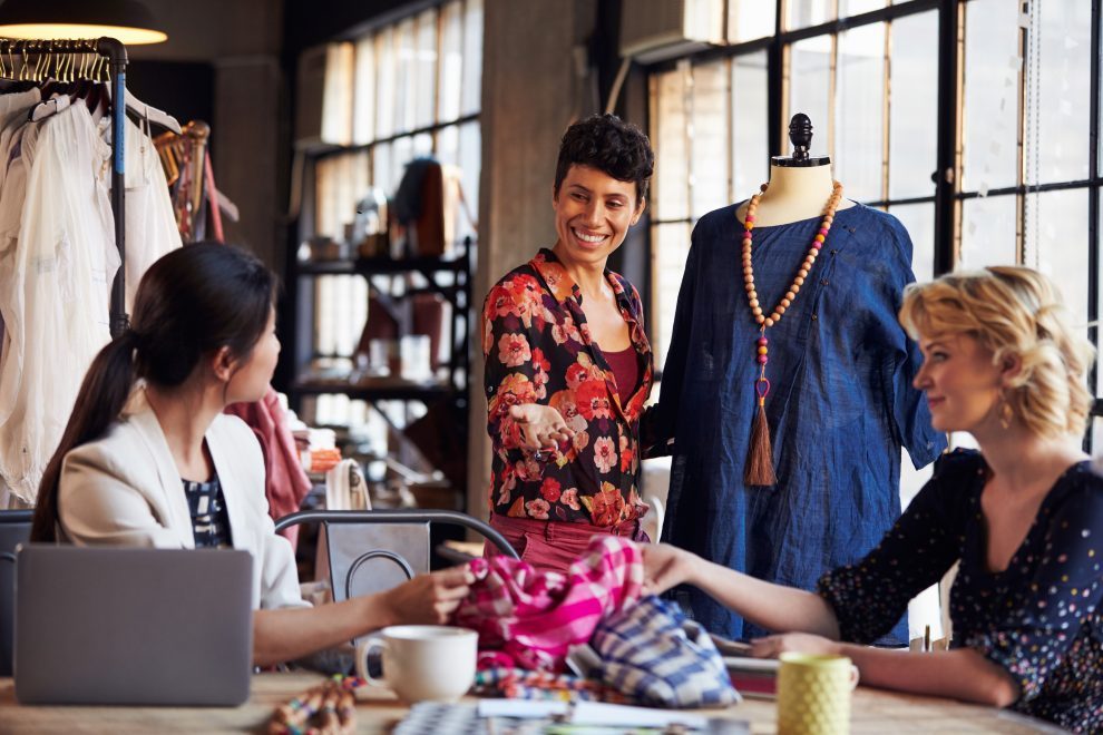 three fashion designers in meeting discussing garment