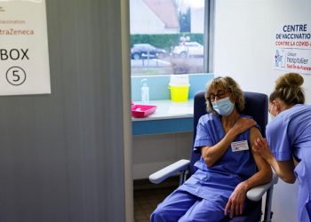 Una mujer recibe la vacuna AstraZeneca en un centro de vacunación. | Thomas Samson, EFE.