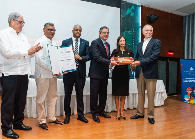 El ministro de Trabajo, Luis Miguel de Camps, entrega un reconocimiento al Banco Popular, el cual es recibido por los señores María Povedano, vicepresidenta ejecutiva de Gestión Humana, Transformación Cultural y Sistemas y Procesos, y Miguel Ángel Rodríguez, vicepresidente ejecutivo de Operaciones. | Fuente externa.