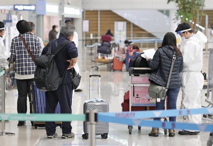 Personal del aeropuerto internacional de Incheon, al este de Seúl, comprueban que los pasajeros que llegan, lo hacen con una PCR negativa.  |Yonhan vía EFE.