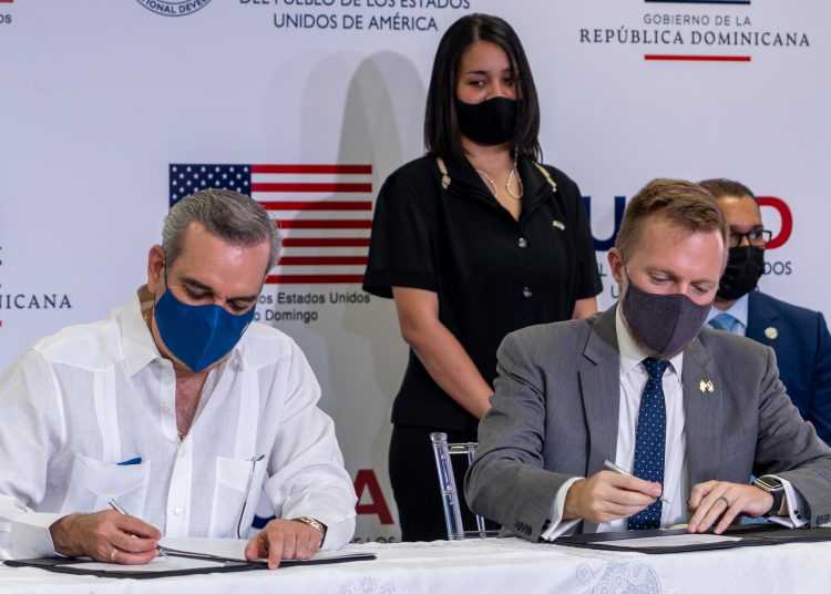 El presidente, Luis Abinader, y el encargado de negocios de la embajada de los Estados Unidos, Robert W. Thomas, durante la firma del acuerdo. | Fuente externa.