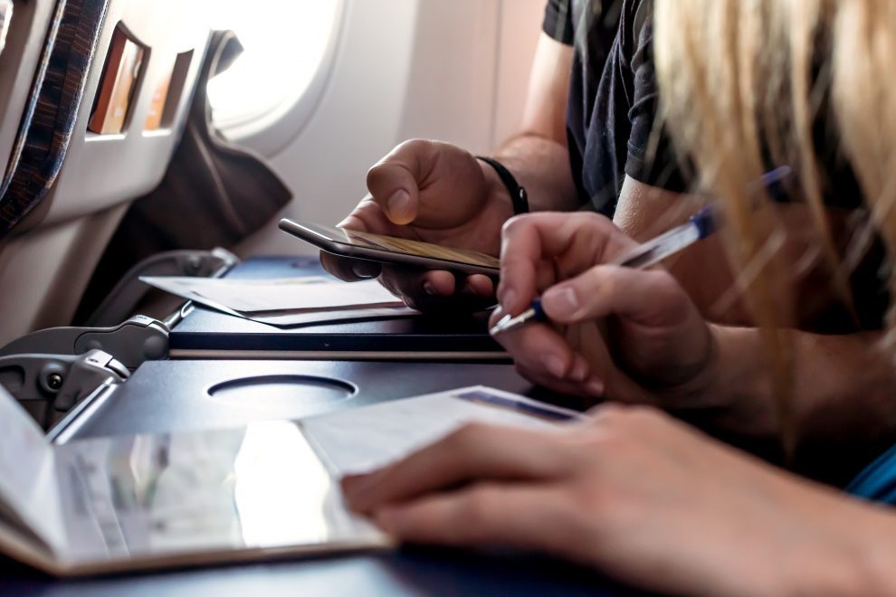 passengers filling in immigration forms in the aircraft